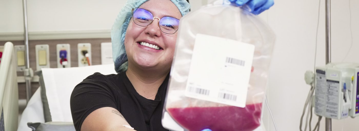 Profesional sonriente sostiene una bolsa de células donadas